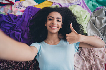 High angle view photo of young girl make selfie show thumb up pile stack clutter clothes apartment...