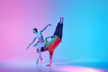 Urban Ballet Fusion. Elegant ballerina dancing with man performing hip hop on a vibrant...