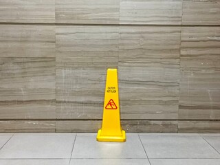 Yellow caution wet floor warning sign on the floor. Floor cleaning process in public rest room.