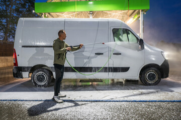 Man Pressure Washing and Cleaning White Van