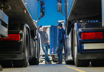 Two Truckers Talking Business in Front of a Semi Trucks