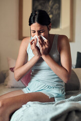 Young, woman and blowing with nose in bedroom for health, virus or infection in spring. Female...