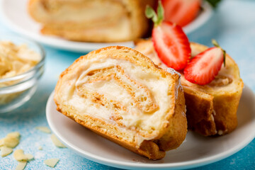 Sliced rolls with custard. The dessert is decorated with fresh strawberries