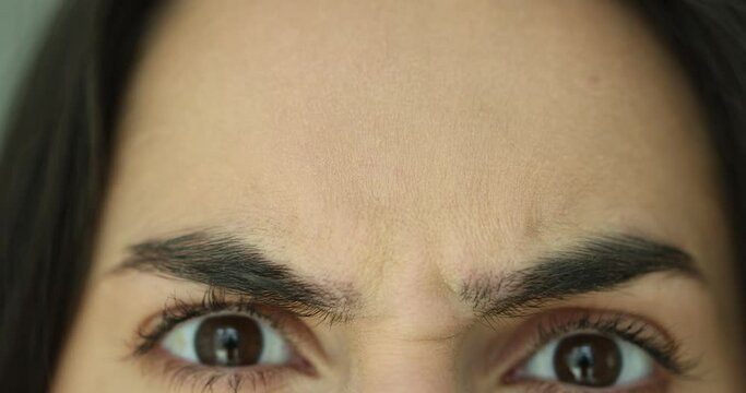 Latina woman frowning and wrinkling eyebrows closeup 4k movie slow motion. Moving facial expressions concept