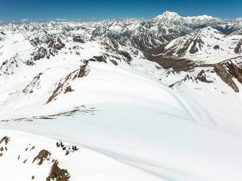 Aerial view of snow-covered Deosai National Park with skiers and Nanga Parbat Mountain, Skardu, Pakistan.