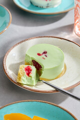 Pistachio Cheesecake with Raspberry Topping on Stylish Ceramic Plate