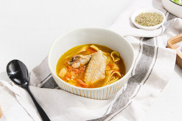 Delicious Chicken Wing Noodle Soup: Comfort Food in White Bowl on Rustic Tablecloth