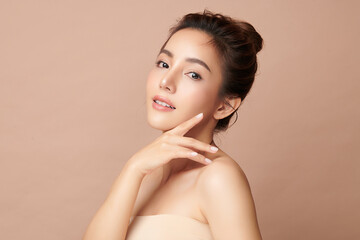 Beautiful young asian woman with clean fresh skin on beige background, Face care, Facial treatment,...