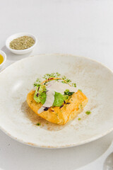 Golden Puff Pastry Filled with Meat on a White Plate with Seasoning and Herbs
