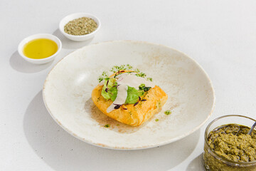 Golden Puff Pastry Filled with Meat on a White Plate with Seasoning and Herbs