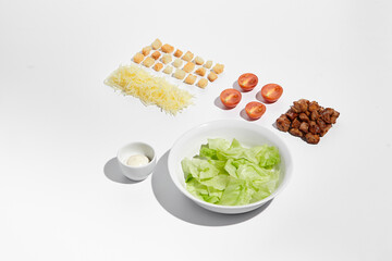 Deconstructed Caesar salad ingredients with neat geometry isolated on white background