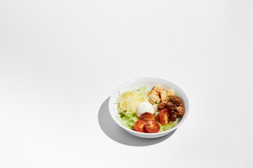 Classic Caesar salad prepared and served in a white bowl