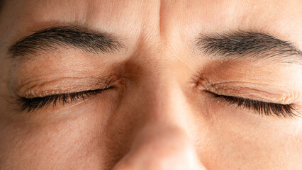 Obraz premium Close up of woman squinting eyes closed