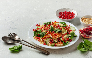 healthy halloumi cheese and couscous salad with cucumber spinach pomegranate hummus