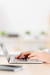 Close-up vertical photo of a Young man working at home with laptop