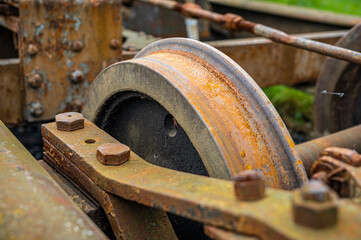 details of a train carriage chassis, with wheels, nuts, bolts and mechanisms jam and rusted