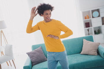Portrait of nice young man dance good mood wear yellow pullover white interior flat indoors