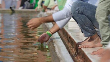 Close up shot of Indian Muslims washing their hands at the ablution pond during Ramadan at Jama Masjid mosque in Old Delhi, India.  