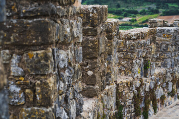 Protective stone wall in the village of Obidos in Portugal. Close-up photo.