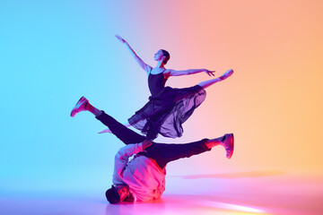 Visual Dance Symphony. Grace of ballet and agility of breakdancing, man performing street dance and girl dancing ballet in neon light. Concept of classical and modern dance, performance