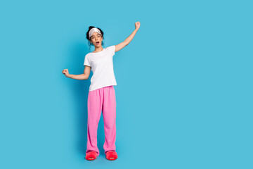 Full size photo of nice young woman yawn stretch empty space wear pajama isolated on blue color...