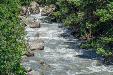 The bubbling clear water of a mountain river with large stones high in the mountains. Clean water...