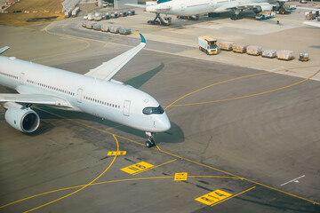 Aerial view of the airport road markings signs on the surface. Airplane taxiing to terminal.