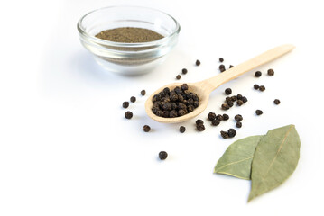 dried bay leaf and black pepper on a white background.