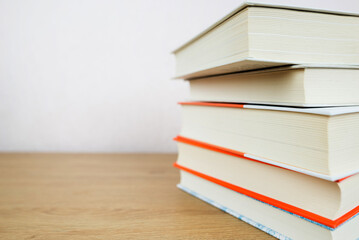 Stack of many old books on shelf in book store or library room with white wall background.