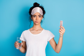 Photo of nice young woman hold pills water wear pajama isolated on blue color background
