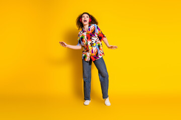 Full length photo of lovely young lady dancing headphones music dressed stylish colorful print garment isolated on yellow color background