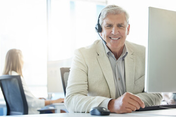Portrait, mature man and call center with headset for customer support, communication or service. Contact us, CRM and consulting agent at desk for student aid, career guidance or scholarship advice