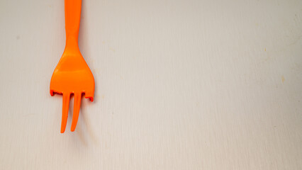 broken orange plastic fork isolated on white with empty space for advertising.