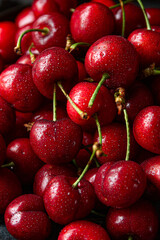 Fresh red cherries on the plate on dark background 