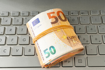 Euro banknotes on a laptop keyboard