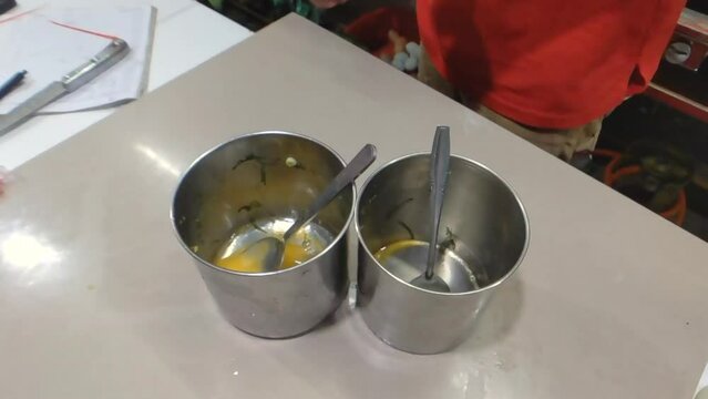 High angle shot of hands cracking the eggs into stainless steel containers in slow motion, preparing to cook an omelette. Perfect for culinary projects or tutorials