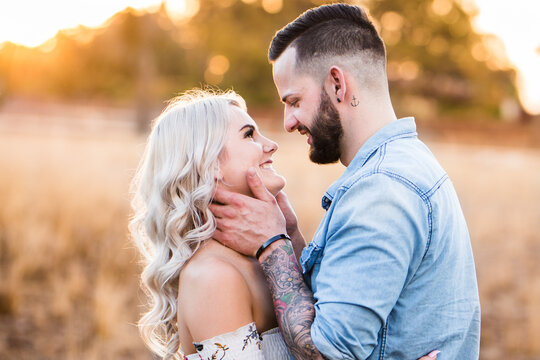 Young couple looking at each other smiling man holding woman's face