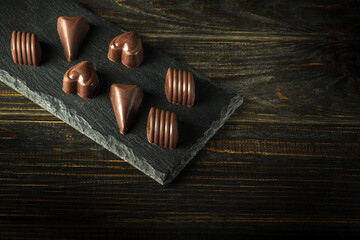 Delicious chocolate candies on a serving black board. Concept of serving dessert in a hotel