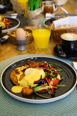 Fried bacon with poached eggs, hash browns and vegetables