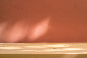 Table with coral pink wall and sunlight reflections. Food, product or cosmetic background.	
