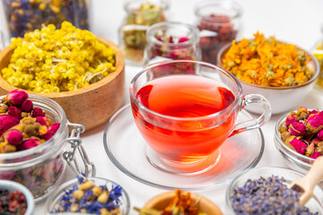 Assortment of dry herbal and berry tea and a cup of tea on a wooden background.Medicinal Healing herbs.Alternative medicine concept.Linden, calendula, cornflowers, marigold, tansy, tea rose.dry herbal