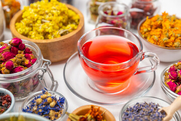 Assortment of dry herbal and berry tea and a cup of tea on a wooden background.Medicinal Healing herbs.Alternative medicine concept.Linden, calendula, cornflowers, marigold, tansy, tea rose.dry herbal