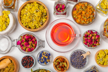 Assortment of dry herbal and berry tea and a cup of tea on a wooden background.Medicinal Healing herbs.Alternative medicine concept.Linden, calendula, cornflowers, marigold, tansy, tea rose.dry herbal