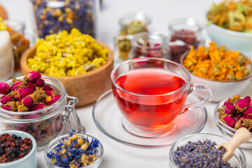 Assortment of dry herbal and berry tea and a cup of tea on a wooden background.Medicinal Healing herbs.Alternative medicine concept.Linden, calendula, cornflowers, marigold, tansy, tea rose.dry herbal