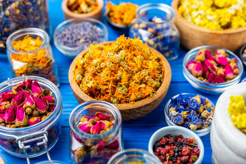 Assortment of dry herbal and berry tea on a wooden background. Tea party concept. medicinal herbs. Healing herbs.Alternative medicine.Linden, calendula, cornflowers, marigold, tansy, tea rose.