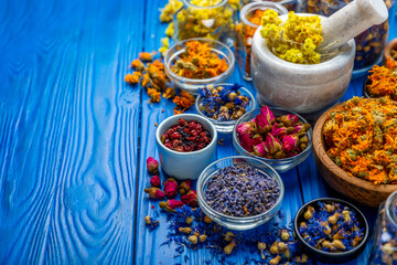 Assortment of dry herbal and berry tea on a wooden background. Tea party concept. medicinal herbs. Healing herbs.Alternative medicine.Linden, calendula, cornflowers, marigold, tansy, tea rose.