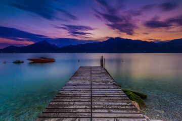 Scenic View of Lake Garda's East Shore with Wooden Pier and Clear Waters