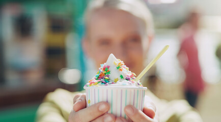 Ice cream, cup and person outside for eat with plastic spoon at beach for fresh air in summer. Dessert, cold and sweet at fair in America with vacation or weekend in sunshine with tasty snack.