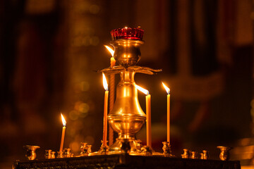 Many burning wax candles in the orthodox church or temple. Candles in a Christian Orthodox church background. Burning candles during church service. 