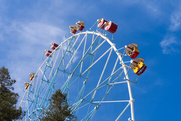 Ferris wheel against the blue sky. Modern Ferris wheel. Big, tall white Ferris wheel in front of a...